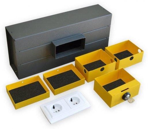 Caja fuerte para empotrar y camuflada frontalmente mediante una base de enchufes